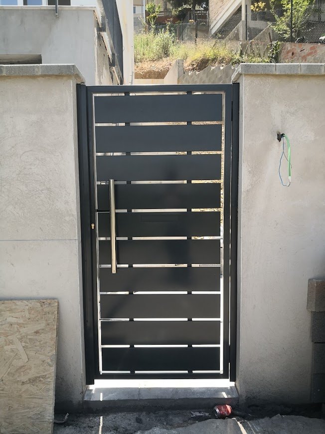 Puerta peatonal moderna con laminas de chapas separadas