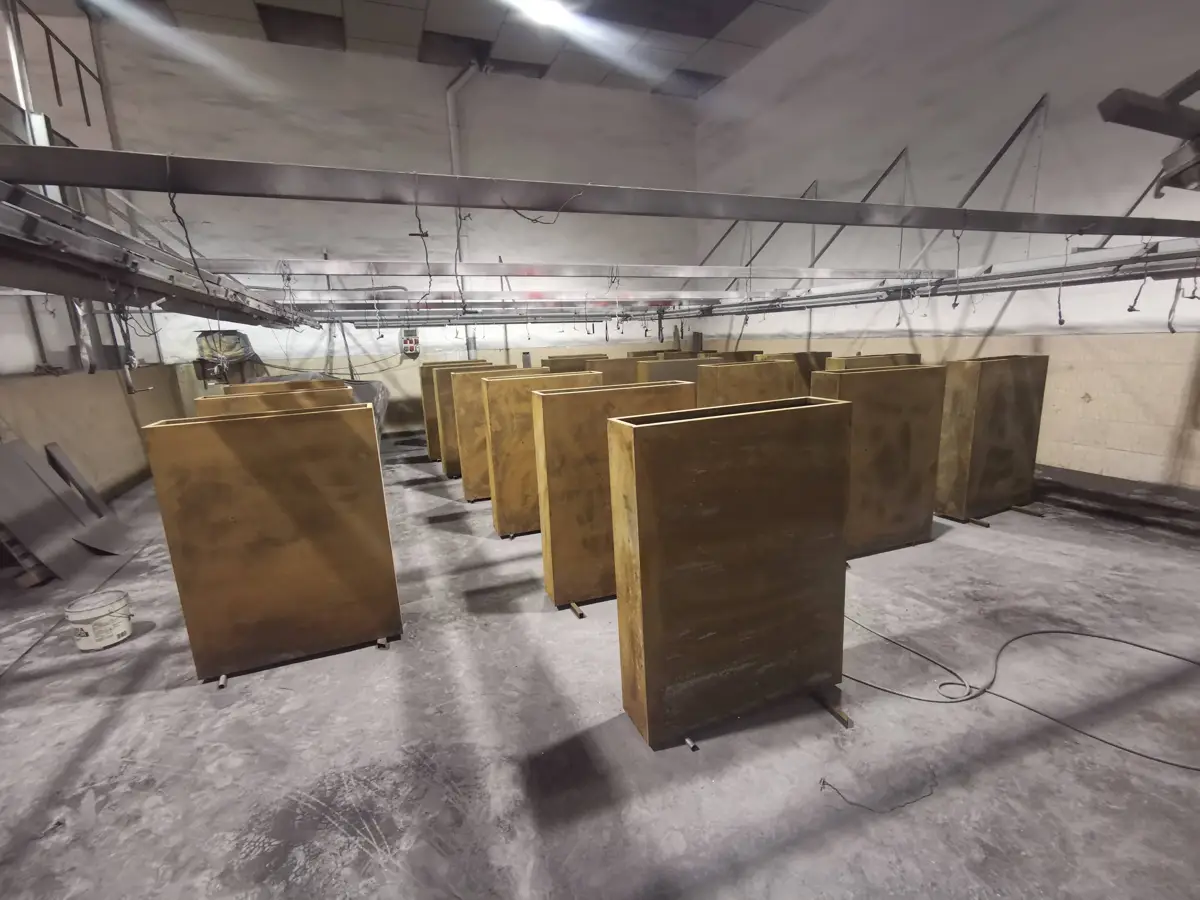 Parts hanging in the Pilonatic powder-coating booth